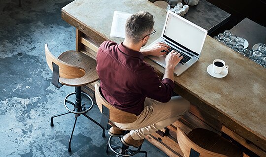 Man at desk typing on laptop
