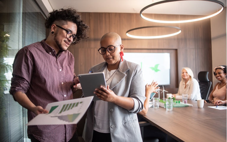Business people talking - including a trans man using tablet