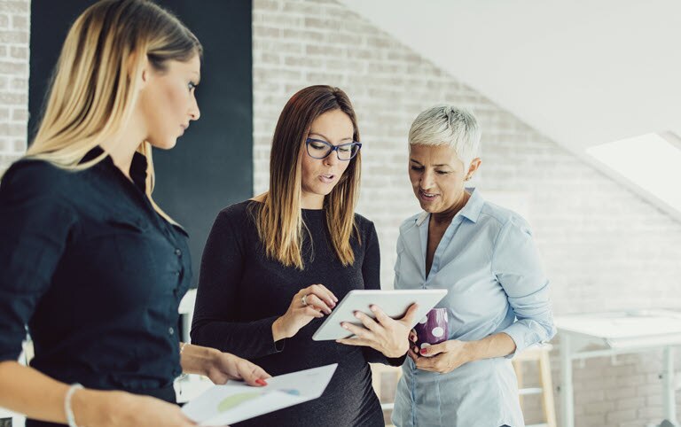 Three women looking at a tablet screen